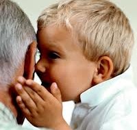 Child whispering into Grandpa's ear