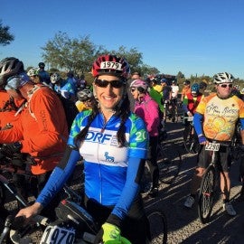 Smiling woman in bike riding gear at a bike riding event | WWMG