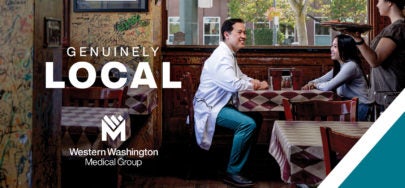 Doctor with scrubs on sitting in a pizza retaurant with a plain-clothed woman - Text states "Genuinely Local - Western Washington Medical Group" | WWMG