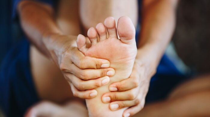 young woman massaging her painful foot , health care concept