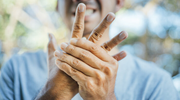 Young Asian Man suffering from pain in hand wrist , Health and pain concept