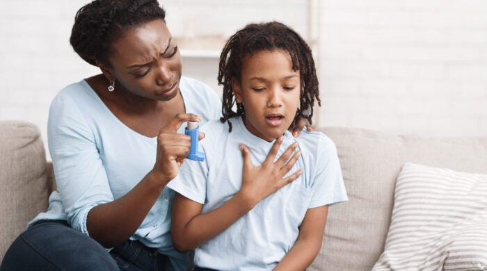 African Girl Having Asthma Attack, Worried Mom Giving Her Inhaler For Relief. Copy space