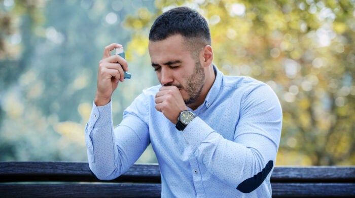 Man using asthma inhaler. Health care concept