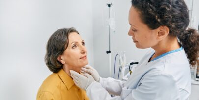 female doctor checking lymph nodes on neck of female patient